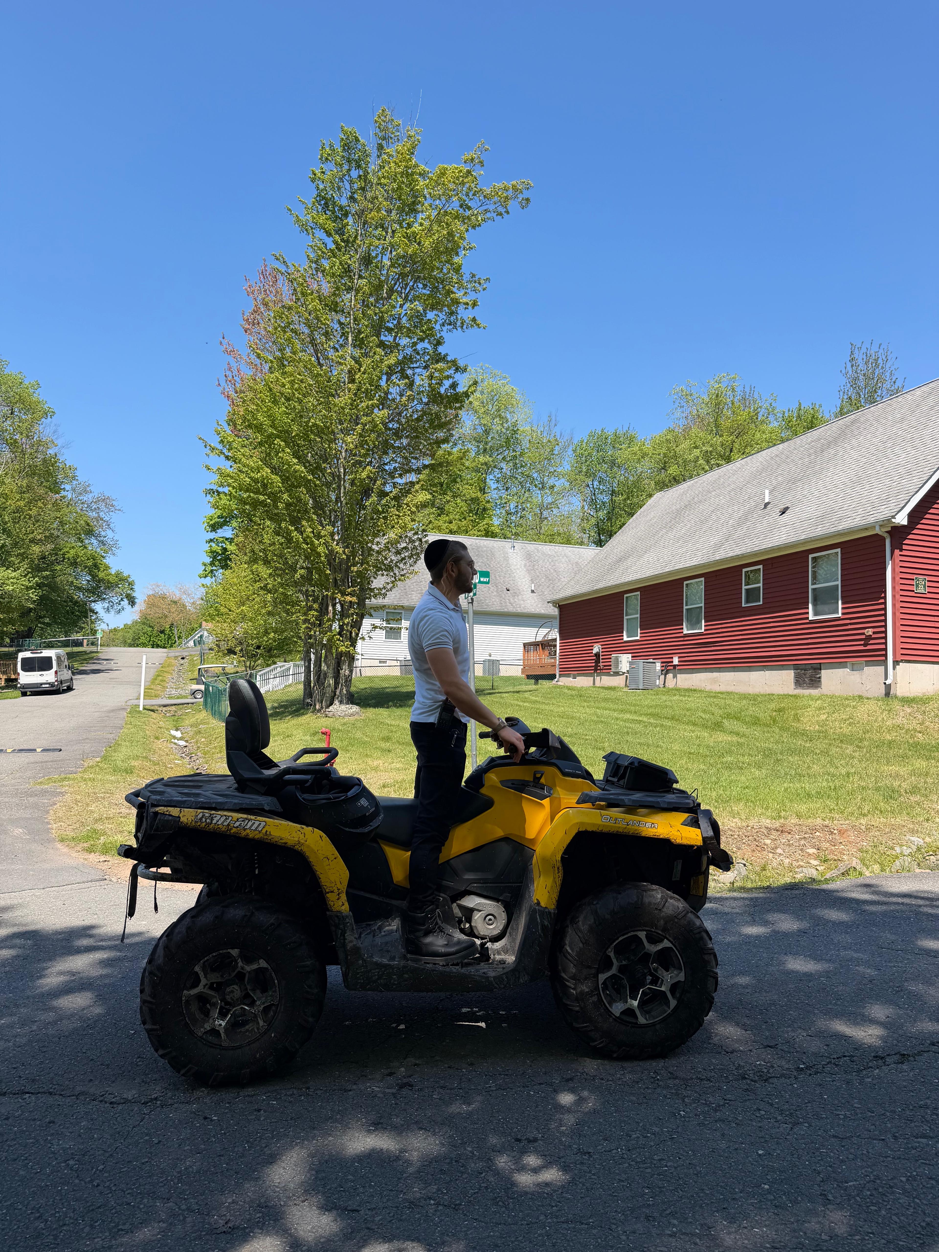 Chavivim member on the SAR ATV staged outside a red bungalow colony building